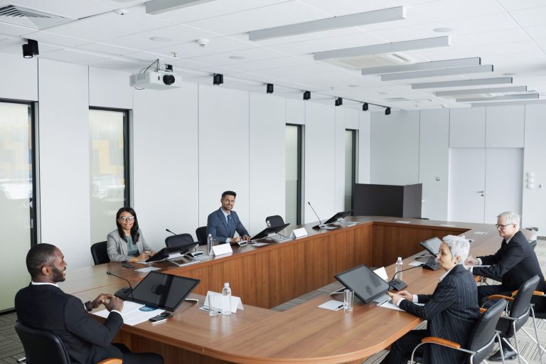 São José dos Campos lança programa com 13 embaixadores para ampliar conexões internacionais Grupo multicultural de profissionais reunido em uma sala de conferências durante uma reunião de negócios.