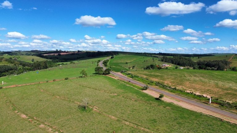 Vista aérea de áreas verdes, lavouras e estradas em uma região rural brasileira.